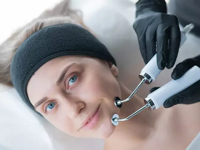 A young woman having the best microcurrent facial device treatment 